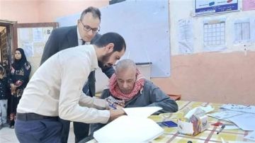 صور.. رئيس لجنة يساعد مسن على الإدلاء بصوته في الهرم