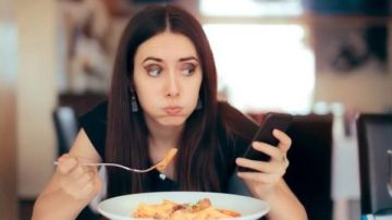 ماذا يحدث لجسمك عند تناول الطعام وأنت تمسك الهاتف؟ دراسات تكشف مفاجآت