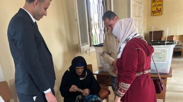 مساعدة مسنة في الشرقية للإدلاء بصوتها بـ انتخابات النواب 2025 مساعدة مسنة في الشرقية للإدلاء بصوتها بـ انتخابات النواب 2025