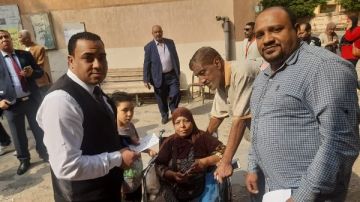 شاهد.. قاضي بصفط اللبن يخرج من لجنته لمساعدة سيدة على كرسى متحرك