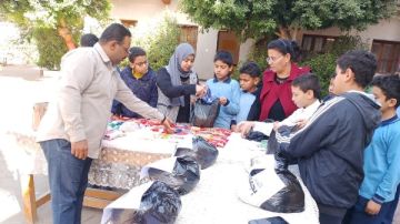 تلاميذ مدرسة أرمنت الابتدائية يشاركون في تعبئة شنط رمضان بالأقصر