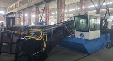 زورق لتنظيف النفايات العائمة على سطح بحيرة القرعون