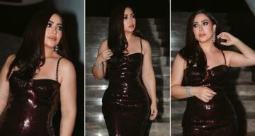 بوسي تخطف الأنظار بفستان برجندي لامع