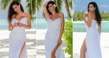 رشاقة تنافس عارضات الأزياء ... ياسمين صبري بفستان أبيض بفتحة جانبية طويلة في جلسة تصوير بالمالديف