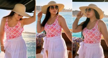 بوسي بكاش مايوه أبيض وقبعة كبيرة في جلسة تصوير خلال رحلة بحرية