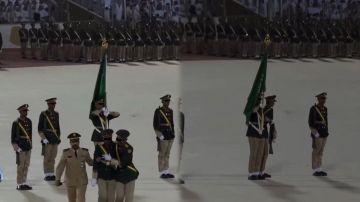 طالب يرفع الراية بيد وبالأخرى يسند زميله المغمى عليه خلال حفل تخريج كلية الملك عبد العزيز الحربية